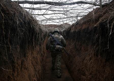 A serviceman of Ukrainian Military Forces walks along trench on his position on the front line with Russia backed separatists not far Novolugansk, Donetsk region on February 16, 2022. (Photo by Anatolii STEPANOV / AFP) (Photo by ANATOLII STEPANOV/AFP via Getty Images)