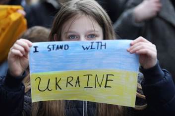 February 26, 2022: People at the GPO in Dublin protesting the Russian invasion of Ukraine. A 9-year-old Ukrainian girl holds a sign saying "I Stand with Ukraine."